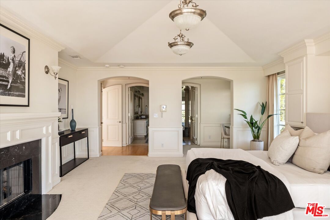 10814 Savona Road Los Angeles, CA 90077 - Photo 17 of 37 a bedroom with a bed and a chandelier
