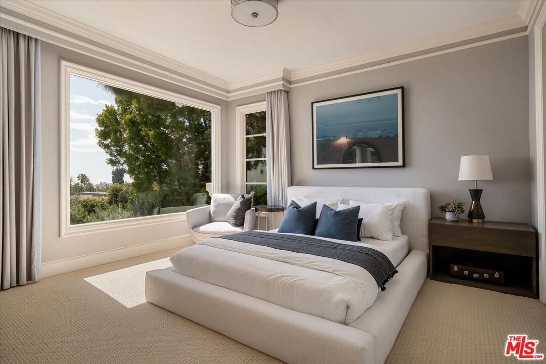 10814 Savona Road Los Angeles, CA 90077 - Photo 24 of 37 a bedroom with a bed a lamp and a large window with outer view