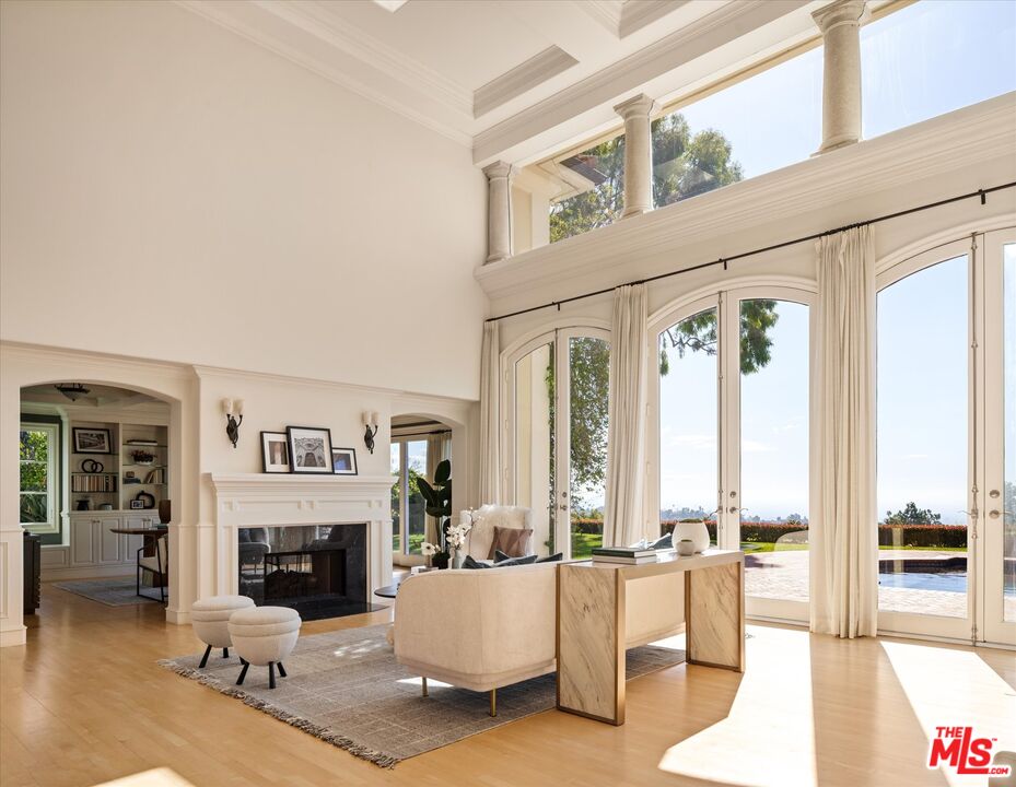 10814 Savona Road Los Angeles, CA 90077 - Photo 6 of 37 a living room with furniture a fireplace and large windows