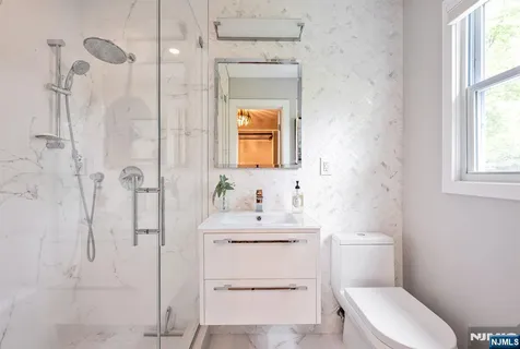 a bathroom with a sink toilet vanity and shower