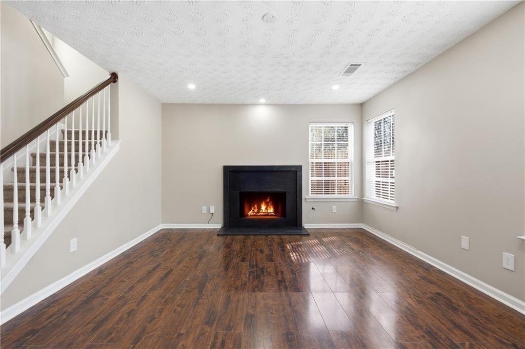 3570 Bogan Mill Road Northeast Buford, GA 30519 - Photo 15 of 31 a view of an empty room with wooden floor fireplace and a window