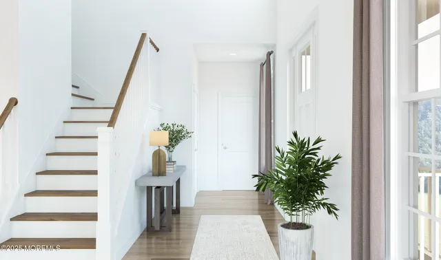 a view of a hallway with wooden floor and stairs
