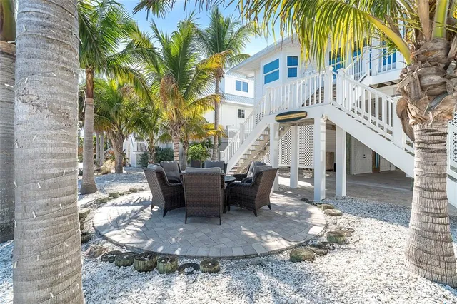 a kitchen with stainless steel appliances kitchen island granite countertop a dining table chairs and a refrigerator