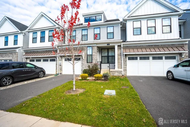 a view of a white house with large windows and a car park front of house