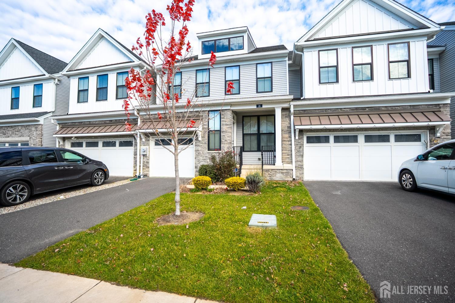 a view of a white house with large windows and a car park front of house