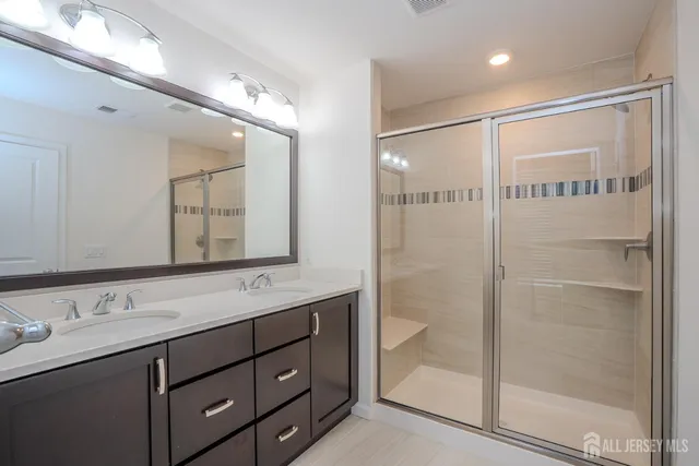 a bathroom with a shower sink and mirror