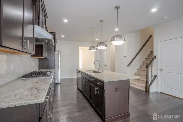 a kitchen with a stove center island and a wooden floor