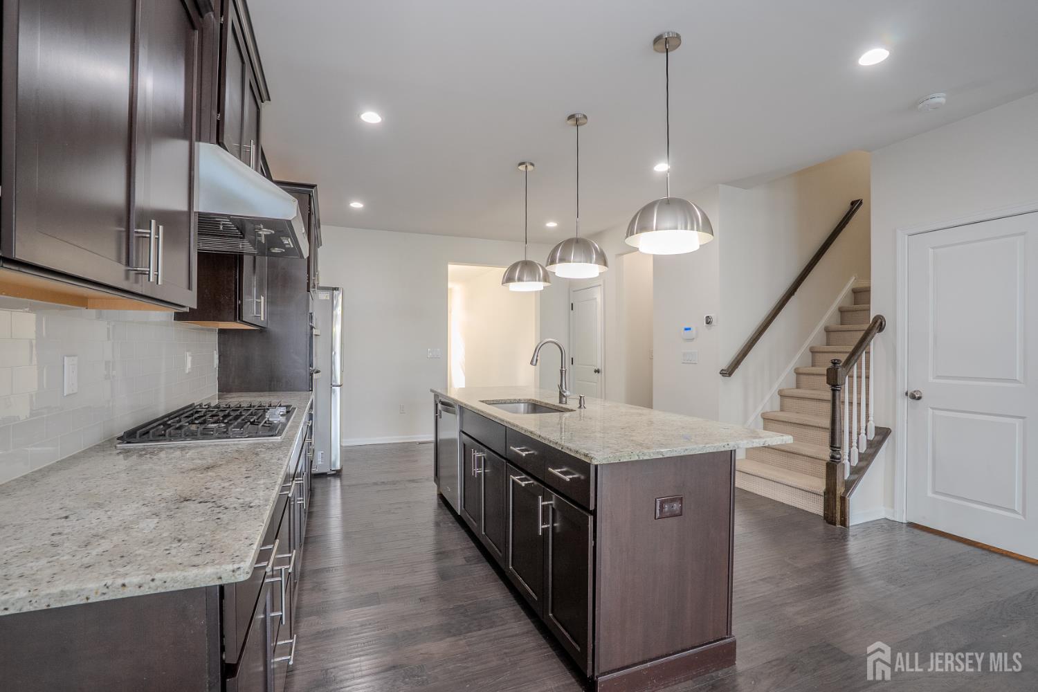 16 Clover Lane Monroe Township, NJ 08831 - Photo 9 of 36 a kitchen with a stove center island and a wooden floor