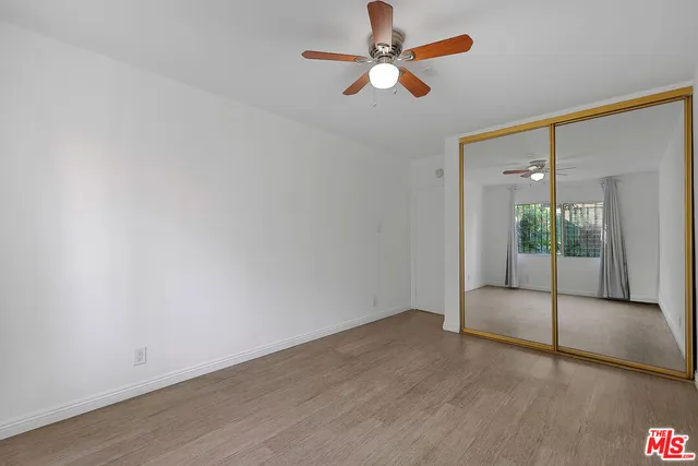 an empty room with fan and glass door