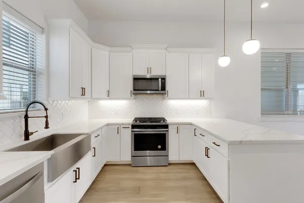 a kitchen with white cabinets and stainless steel appliances