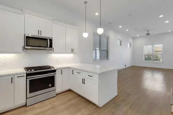 a kitchen with granite countertop white cabinets and stainless steel appliances
