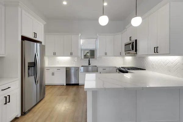 a kitchen with stainless steel appliances granite countertop a sink a stove and a refrigerator