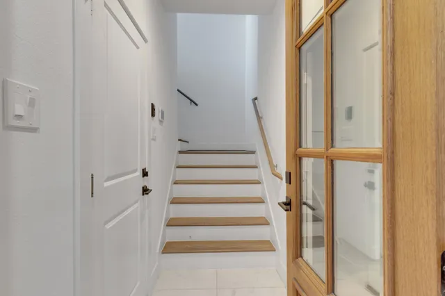 a view of staircase with wooden floor and white walls