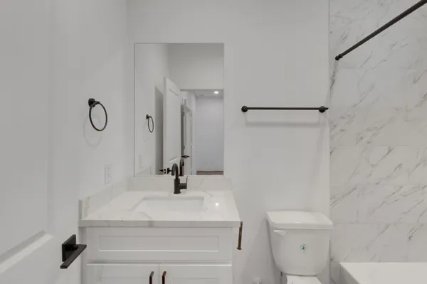 a bathroom with a sink a toilet and a mirror
