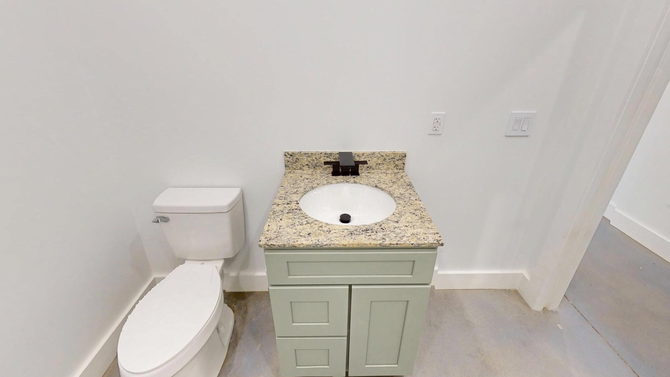 37837 Straughn School Road Out Of State, OUT OF STATE 00000 - Photo 37 of 59 a bathroom with a granite countertop toilet and a sink