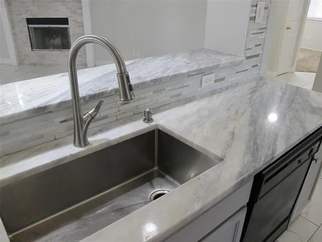 a kitchen with granite countertop white cabinets and black stove top oven with granite countertops