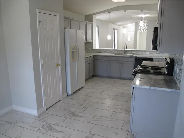 a kitchen with a refrigerator sink and cabinets