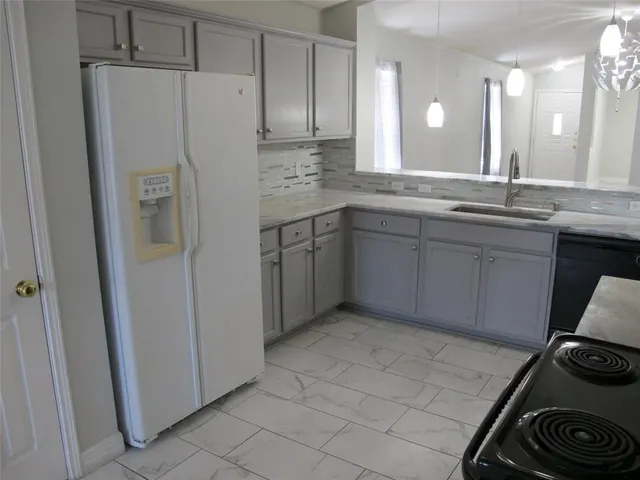 a kitchen with granite countertop white cabinets stainless steel appliances and a sink