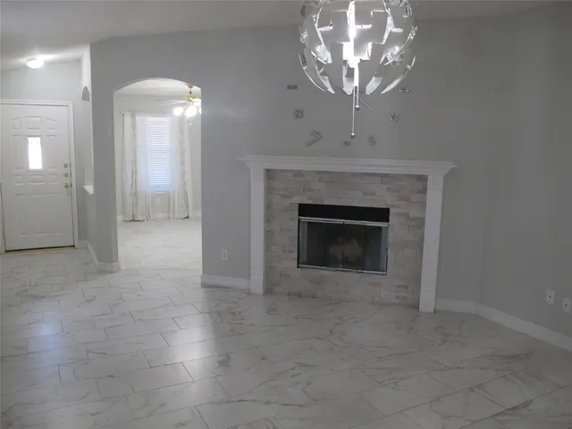 a view of a livingroom with a chandelier fan and a fireplace