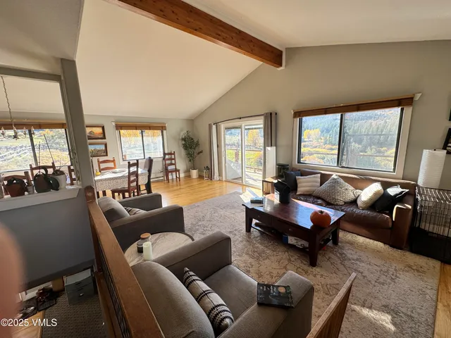 a living room with furniture couches and a large window