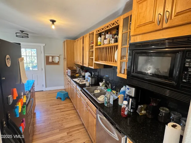 a kitchen with stainless steel appliances a stove and wooden floor