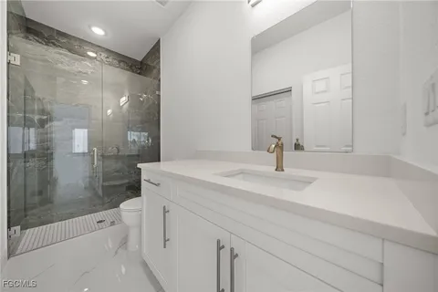 a bathroom with a shower sink and mirror