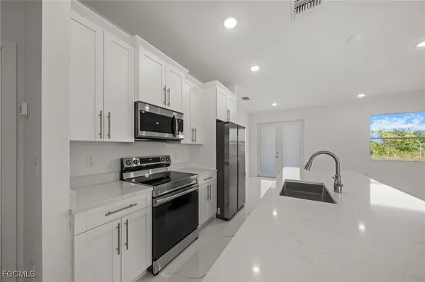 a kitchen with granite countertop a stove and a sink