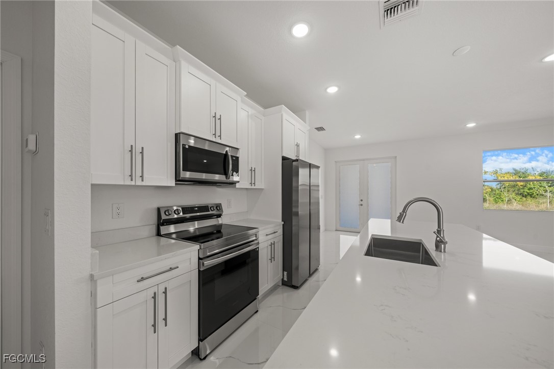 4309 8th Street Southwest Lehigh Acres, FL 33976 - Photo 6 of 25 a kitchen with granite countertop a stove and a sink