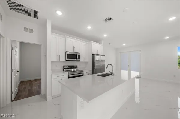 a kitchen with stainless steel appliances granite countertop a sink refrigerator and microwave