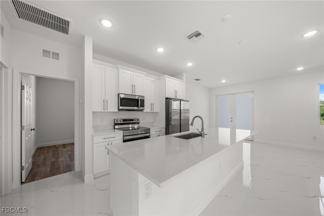 4309 8th Street Southwest Lehigh Acres, FL 33976 - Photo 8 of 25 a kitchen with stainless steel appliances granite countertop a sink refrigerator and microwave