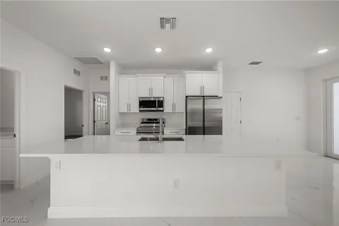 a large kitchen with stainless steel appliances a refrigerator and a stove