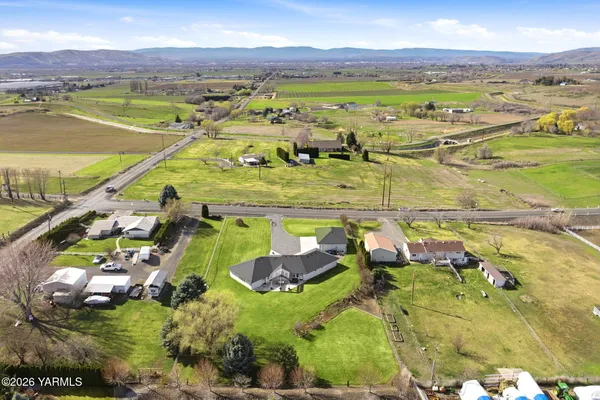 an aerial view of residential houses with outdoor space and trees