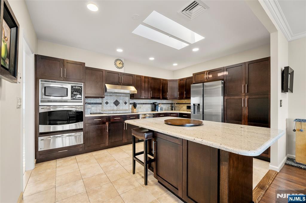 300 Gorge Road, Unit 57 Cliffside Park, NJ 07010 - Photo 11 of 30 a kitchen with stainless steel appliances granite countertop a refrigerator stove microwave and sink