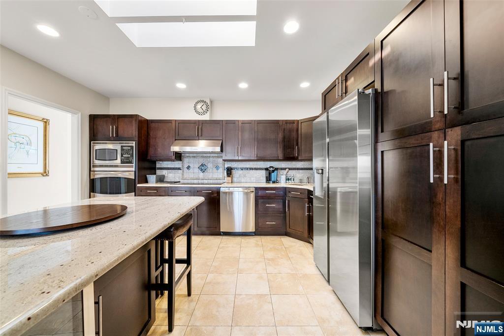 300 Gorge Road, Unit 57 Cliffside Park, NJ 07010 - Photo 12 of 30 a kitchen with stainless steel appliances granite countertop a refrigerator a stove a sink and a microwave