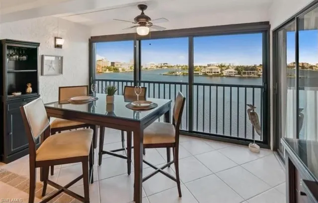 a dining room with furniture a chandelier and window