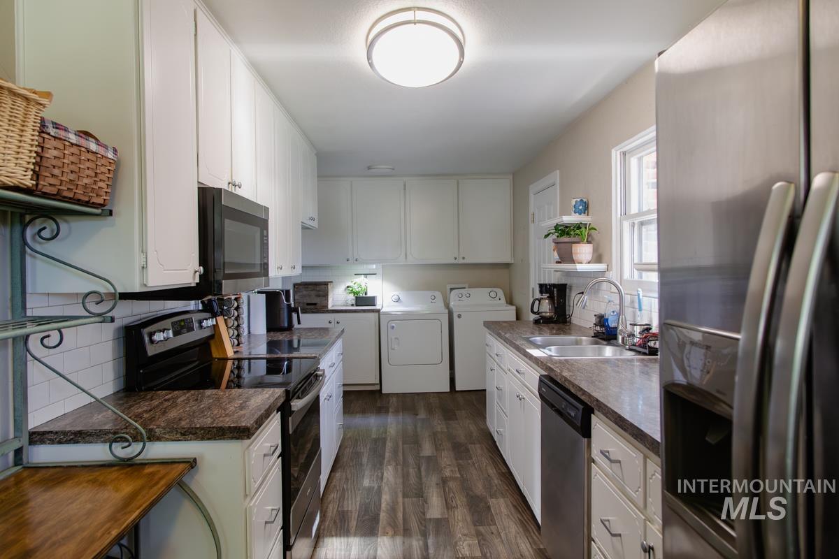 1404 Rochester Street Caldwell, ID 83605 - Photo 5 of 29 Galley kitchen featuring white cabinetry, dark wood-finish flooring, and a subway tile backsplash