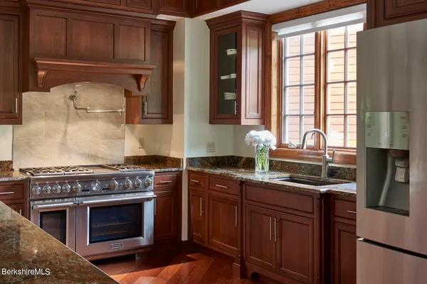 a kitchen with stainless steel appliances granite countertop a stove a sink and a microwave