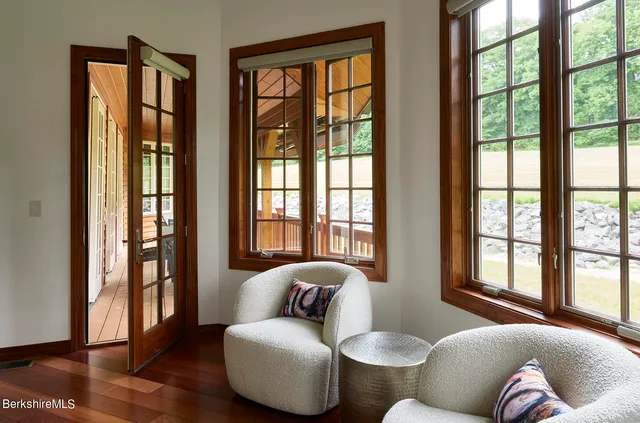 a living room with furniture and two large window