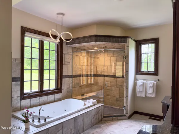 a bathroom with a tub a sink and a large window