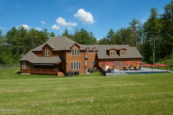 a sign that is sitting in front of a house with a yard