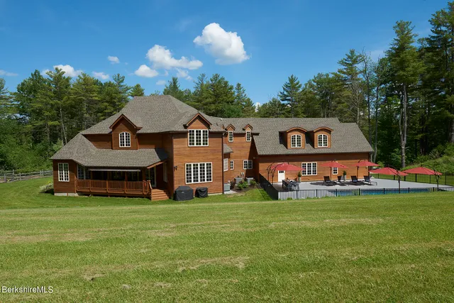 a sign that is sitting in front of a house with a yard