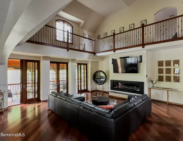 a living room with furniture a flat screen tv and a floor to ceiling window