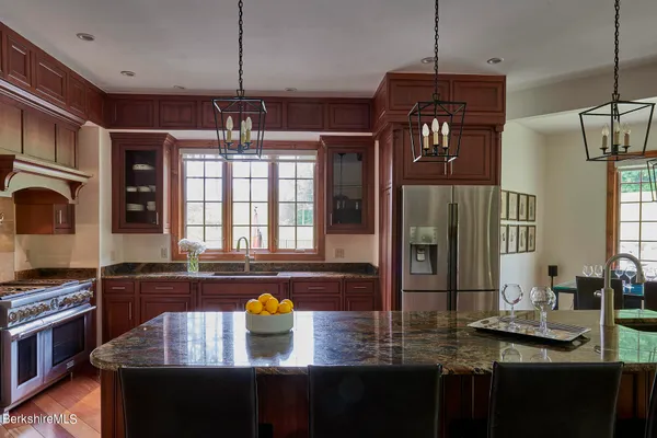 a kitchen with kitchen island granite countertop a sink and a stove