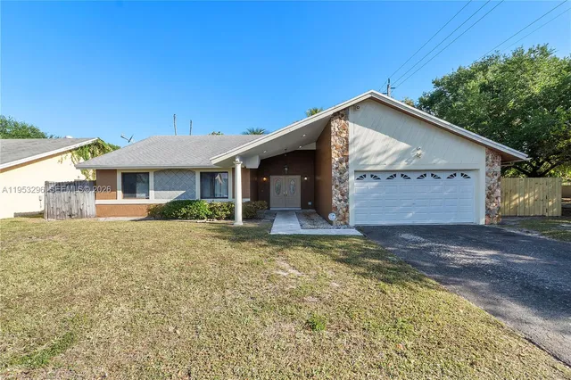 a view of a house with a yard and garage