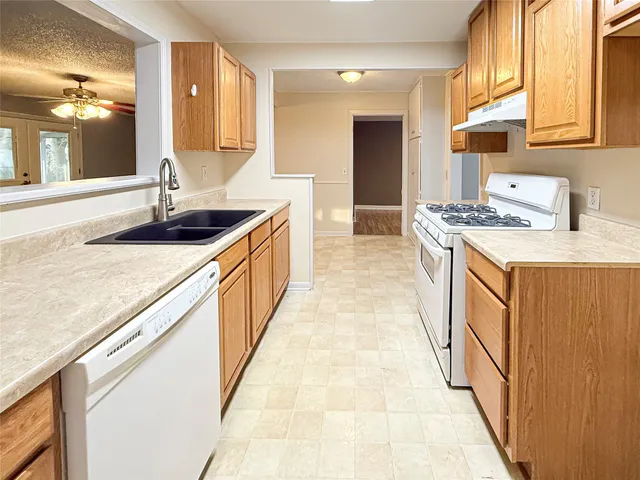 a kitchen with stainless steel appliances granite countertop a sink and a stove