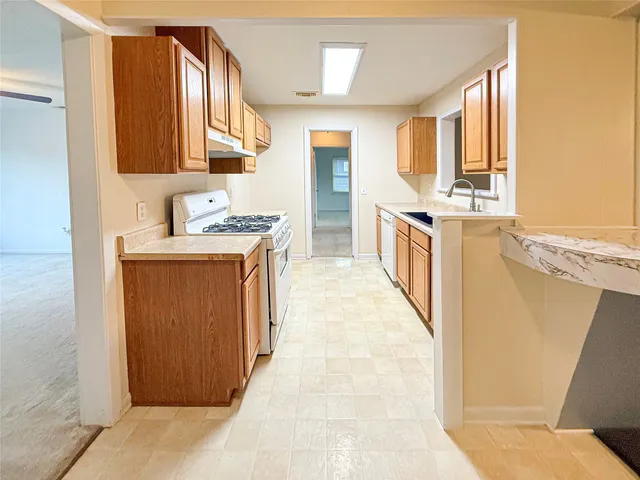 a view of a kitchen with stainless steel appliances granite countertop a stove top oven