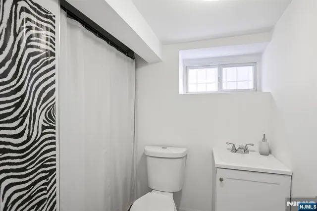 a bathroom with a sink a toilet and a window