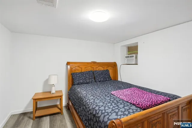 a bedroom with a bed and a lamp with wooden floor