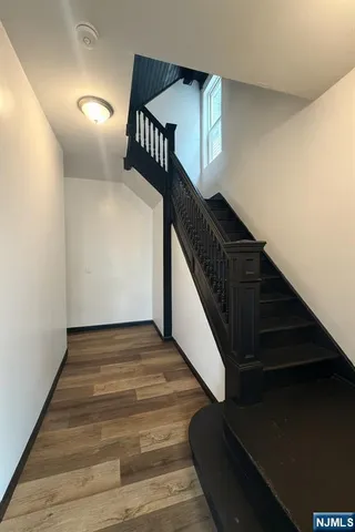a view of entryway and hall with wooden floor