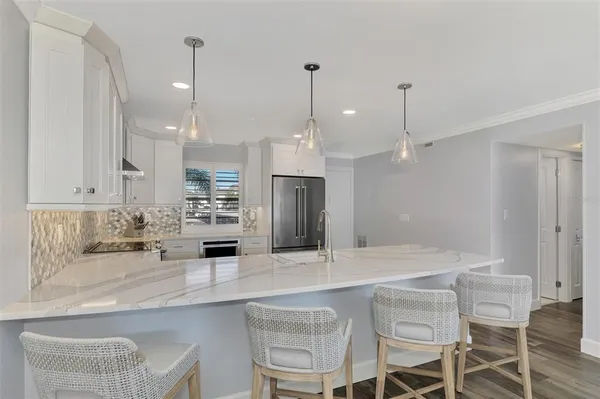 a kitchen with stainless steel appliances a refrigerator and a stove top oven